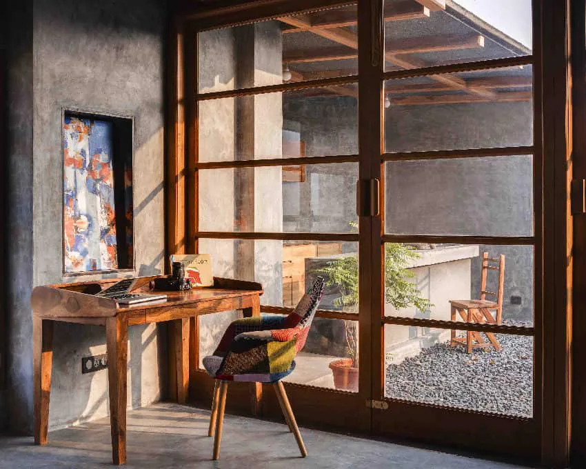 A peaceful sunroom study room integrated with a deep veranda—natural light-filled workspace for a luxury farmhouse in Attappadi.